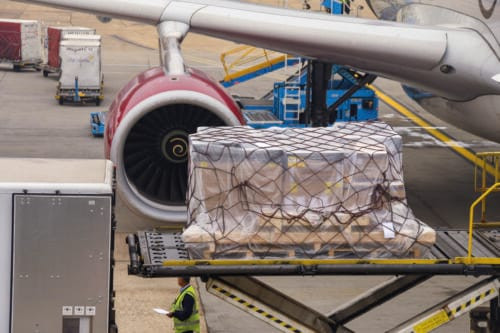 LONDON HEATHROW AIRPORT - JUNE 2018: Close up view of an air feight pallet being loaded into the cargo hold of a Virgin Atlantic Airbus A330 at London Heathrow Airport.